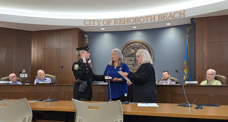 The Rehoboth Beach Police Department swore in two officers during a commissioner workshop Oct. 6. Shown is Ptlm. Samantha Burns being sworn in by Alderman Court 37 Judge Renee L. Bennett, with city executive assistant Tracey Rummel holding the Bible. CHRIS FLOOD PHOTOS